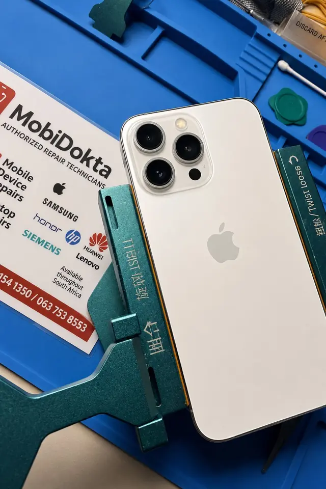 A white iPhone 13 Pro on the MobiDokta bench after a back glass replacement